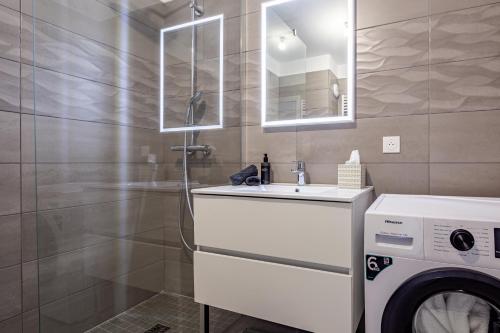 ein Badezimmer mit einem Waschbecken und einer Waschmaschine in der Unterkunft Monaco à pied in Beausoleil