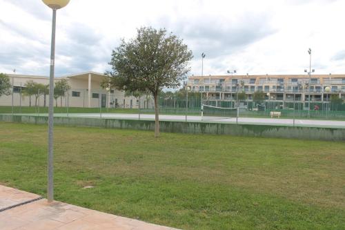 a tree in a field in front of a building at Panorámica Golfmar c/ Generalitat in Sant Jordi
