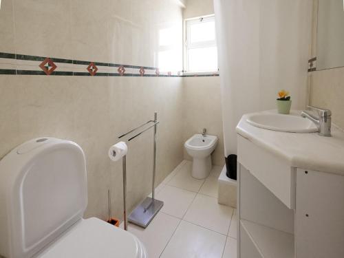 biała łazienka z toaletą i umywalką w obiekcie Praia da Oura Apartment - 100 m from the Beach - By Bedzy w Albufeirze