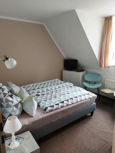 a bedroom with a bed and a table with a lamp at Pension Sonnenblick in Brüel