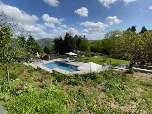 a swimming pool in a yard with a field at Agriturismo Poderi Zunino in Ponti