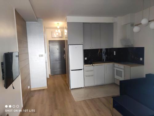 a kitchen with white cabinets and a white refrigerator at Perła Apartament Mińsk in Mińsk Mazowiecki