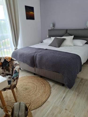 a bedroom with a large bed and a chair at Boutique Resort OSMA - Adults Only in Malinska