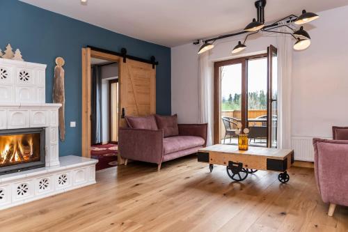 a living room with a fireplace and a couch at udanypobyt Dom Forest Prestige House in Rzepiska