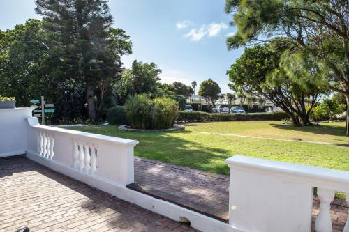 a white fence with a park in the background at Whale Rock Luxury Lodge in Hermanus