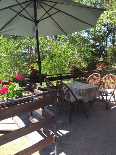 a table and chairs with an umbrella on a patio at vila Borova glava in Zlatibor
