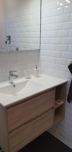 une salle de bain avec un lavabo blanc et un miroir dans l'établissement Appartement avec terrasse quartier Montplaisir, à Arles