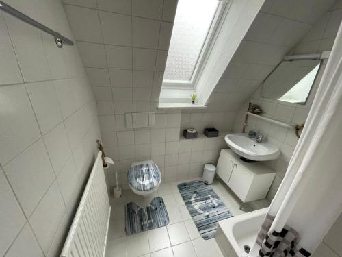 een witte badkamer met een wastafel en een toilet bij Lust auf Meer - Ferienwohnung in Cuxhaven