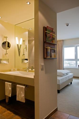 a bathroom with a sink and a bed in a room at Ringhotel Katharinen Hof in Unna