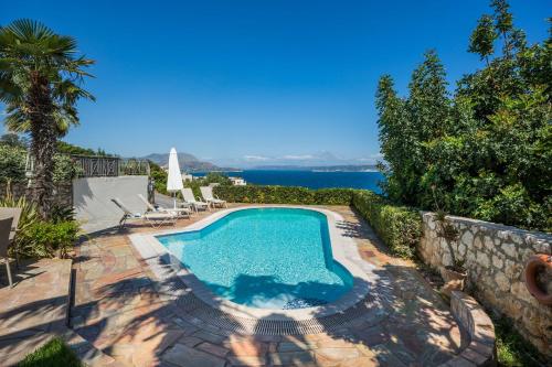 a swimming pool with a view of the water at Villa Nicolas Plaka With Sea View in Plaka