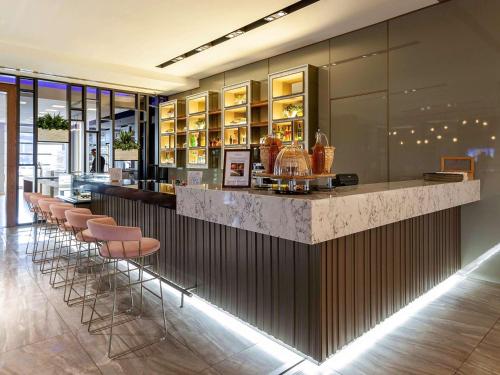 a bar with a row of stools in a restaurant at Novotel Trabzon in Trabzon