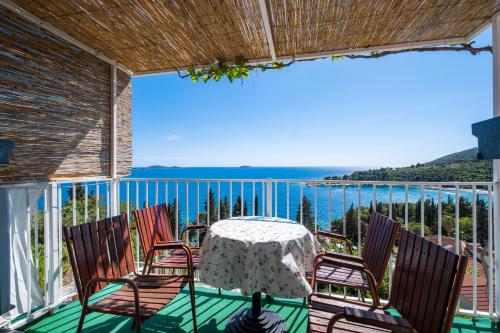 a table and chairs on a balcony with a view of the ocean at Apartments Katica in Mlini