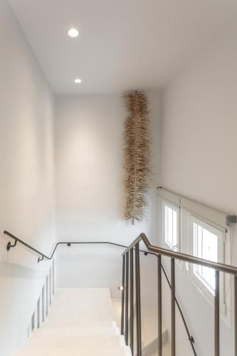 a staircase with a feather hanging on the wall at Sunday Luxury Suites in Agia Anna Naxos
