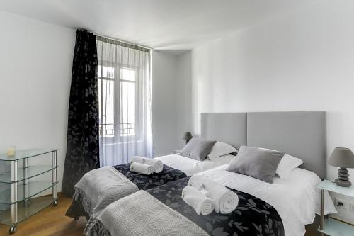 une chambre avec deux lits avec des serviettes dessus dans l'établissement IMMOGROOM - 8 min from the Palais - AC - Quai St Pierre, à Cannes
