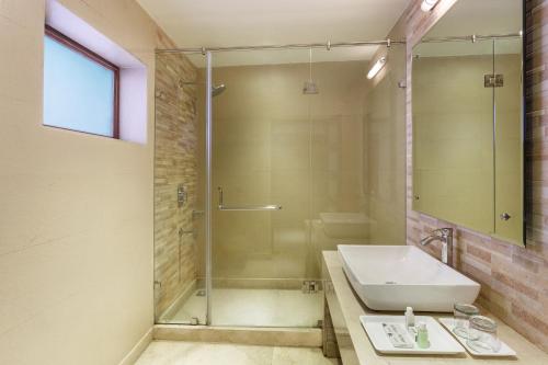 a bathroom with a sink and a glass shower at The Earls Court by Leisure Hotels in Nainital