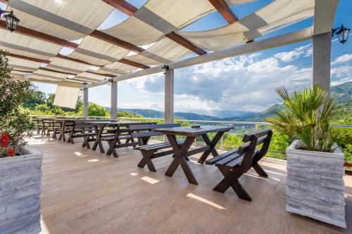 a picnic table on a deck with mountains in the background at Resort Bevilacqua in Budva