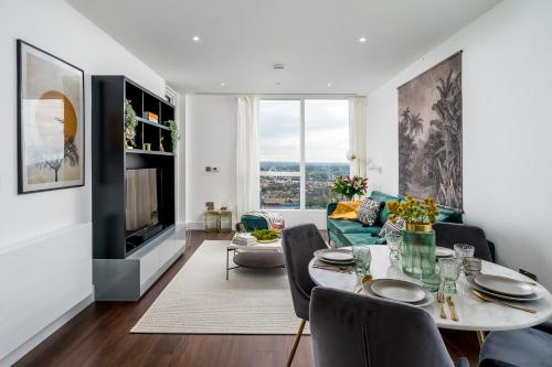 a living room with a table and a couch at Luxurious Spacious 2Bed Suites Skyline River Views by Canary Wharf in London