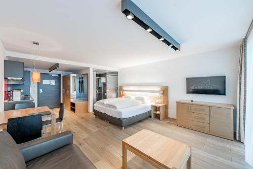 a bedroom with a bed and a living room at Sport- und Genusshotel Silvretta in Ischgl