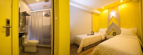 マラッカにあるSunshine Inn Plusの黄色の部屋(ベッド2台、トイレ付)