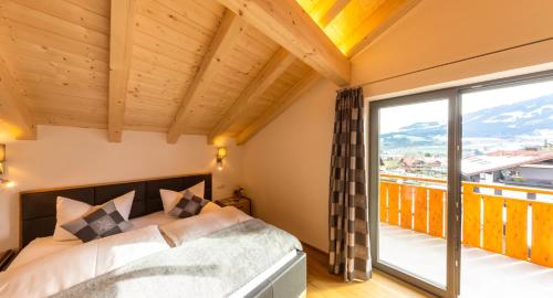 ein Schlafzimmer mit einem Bett und einem großen Fenster in der Unterkunft Haus Allgäublick in Fischen im Allgäu