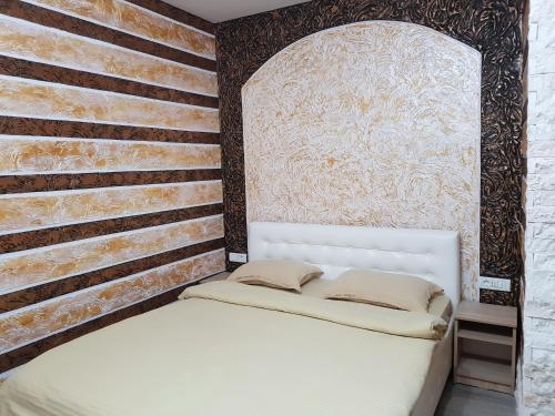 a bedroom with a white bed and a wall at Casa Lipianu in Târgu Jiu
