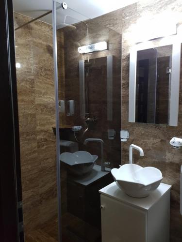 a bathroom with two sinks and a mirror at Casa Lipianu in Târgu Jiu