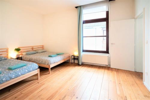 a bedroom with two beds and a large window at The Antwerp Old Town Lodge in Antwerp