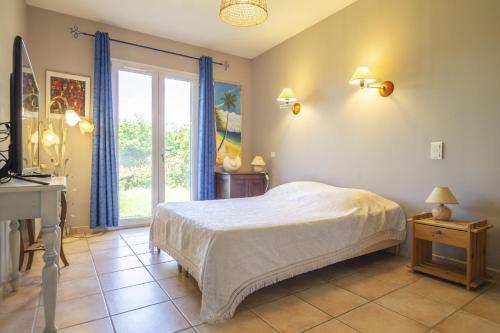 une chambre avec un lit, un bureau et une fenêtre dans l'établissement Villa les Buisses, à Piolenc