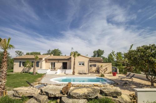 une maison avec une piscine dans une cour dans l'établissement Villa les Buisses, à Piolenc