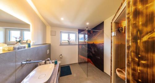 ein Badezimmer mit einem Waschbecken und einer Badewanne in der Unterkunft Haus Allgäublick in Fischen im Allgäu