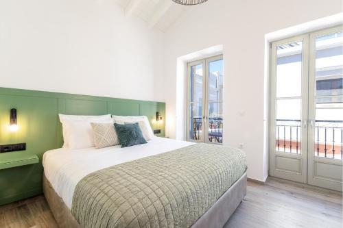 a bedroom with a large bed with a green headboard at Suite Christina in Symi