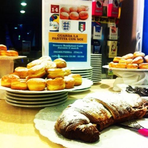 a table topped with pastries and donuts on plates at Hotel Jole in Cesenatico