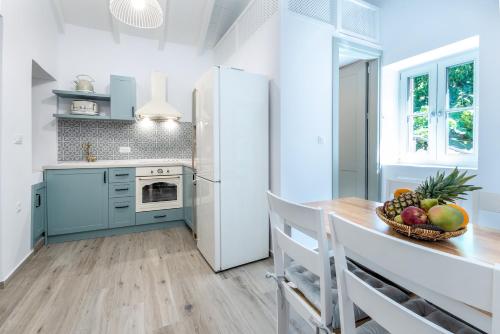 a kitchen with a refrigerator and a table with a bowl of fruit at Suite Christina in Symi