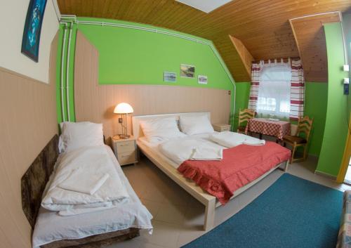 two beds in a room with green walls at Müller's 1 in Siófok