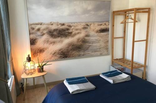 - une chambre dotée d'un lit bleu et d'une peinture murale dans l'établissement Le logis des lavandières, à Honfleur