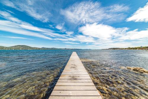 Une jetée en bois s'étend sur une grande étendue d'eau dans l'établissement Hotel Brin d'Azur - Saint Tropez, à Saint-Tropez