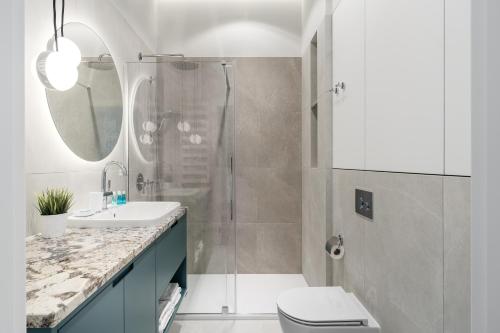a bathroom with a shower and a toilet and a sink at Sanhaus Apartments - Apartament Mera z parkingiem i klimatyzacją in Sopot