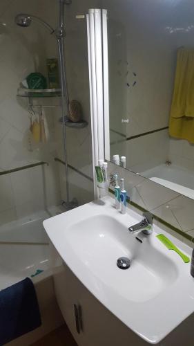 y baño con lavabo blanco y ducha. en Semi-detached Adosado con Encanto -130 m2 - WiFi 600 Mb - Piscina Comunitaria - Patio Privado, en Torremolinos