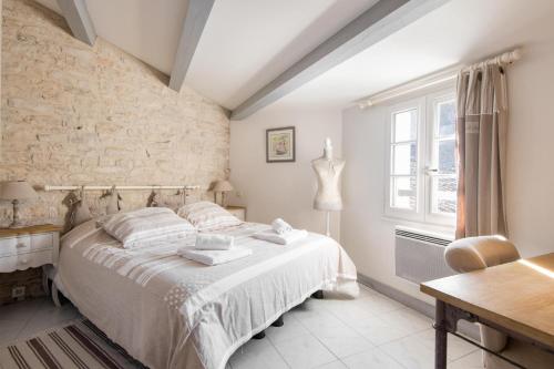 - une chambre avec un lit et un mur en briques dans l'établissement Maison Marceane, à Sainte-Marie de Ré