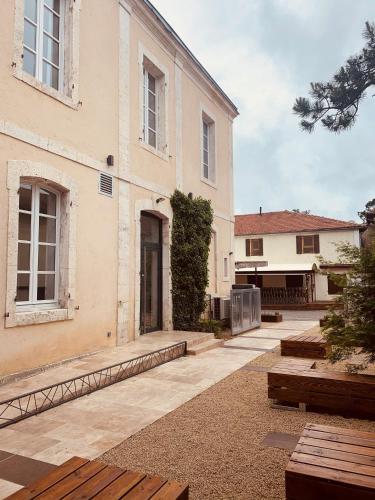 a large white building with benches in front of it at CHEZ FLO in Parentis-en-Born