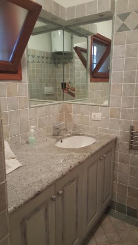 La salle de bains est pourvue d'un lavabo et d'un miroir. dans l'établissement residence approdo, à Cannigione
