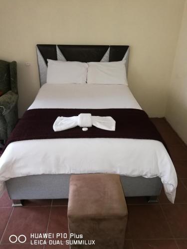 a bed with a bow tie on top of it at SIMA SILVER LODGE in Tzaneen