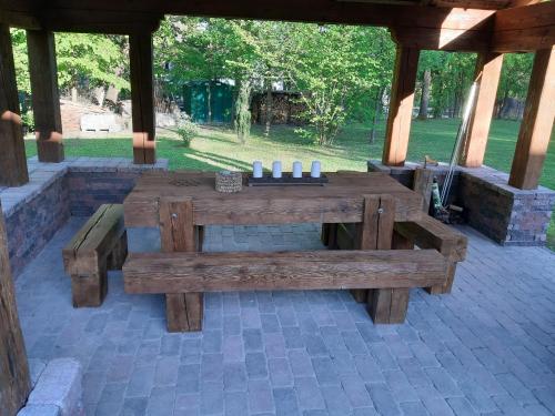 a wooden picnic table and benches in a pavilion at Börzsöny Vendégház in Nagymaros