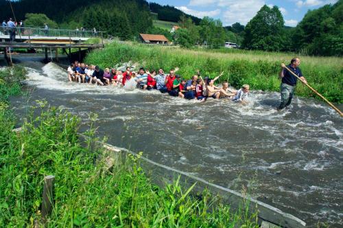 a group of people on a raft in a river at Meister BÄR HOTEL Frankenwald in Berg