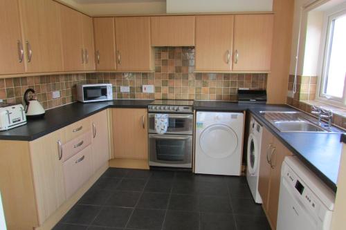 a kitchen with a washer and dryer at Clustiau'r Mor in Tywyn