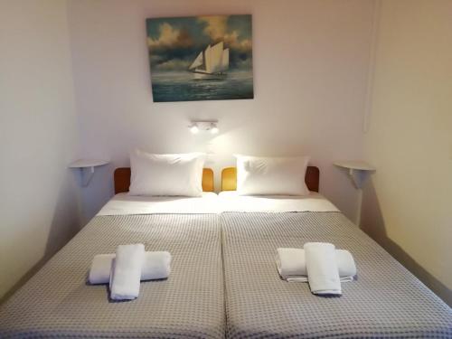 a bedroom with two beds with white pillows at Seatinview Lodges in Mikonos