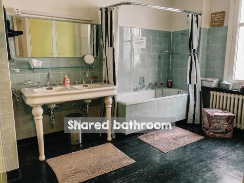 a bathroom with a sink and a shower and a tub at CityLodge St Gallen - 2 min to Marktplatz in St. Gallen