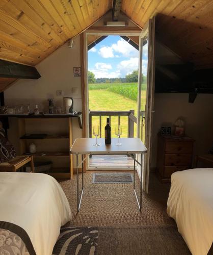 Cette chambre comprend deux lits et une table avec une fenêtre. dans l'établissement La Blanche Roche, à Sourdeval