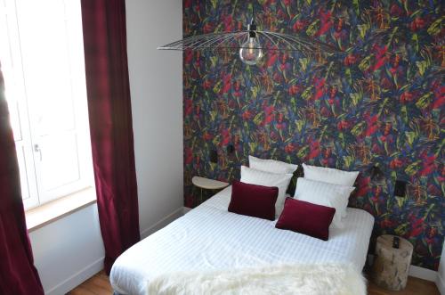 a bedroom with a bed with a colorful wall at CHEZ FLO in Parentis-en-Born