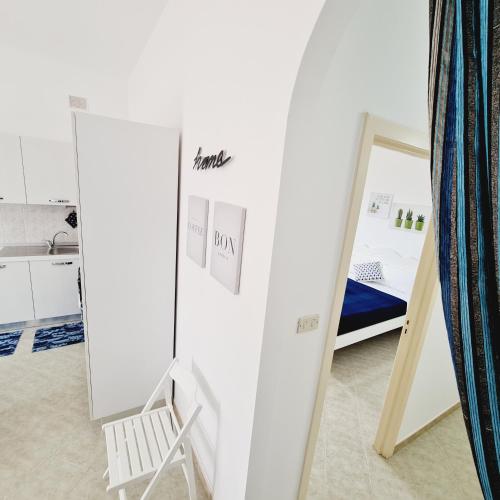 a white room with a mirror and a bed at APPARTAMENTO GIOIA in Torre Lapillo